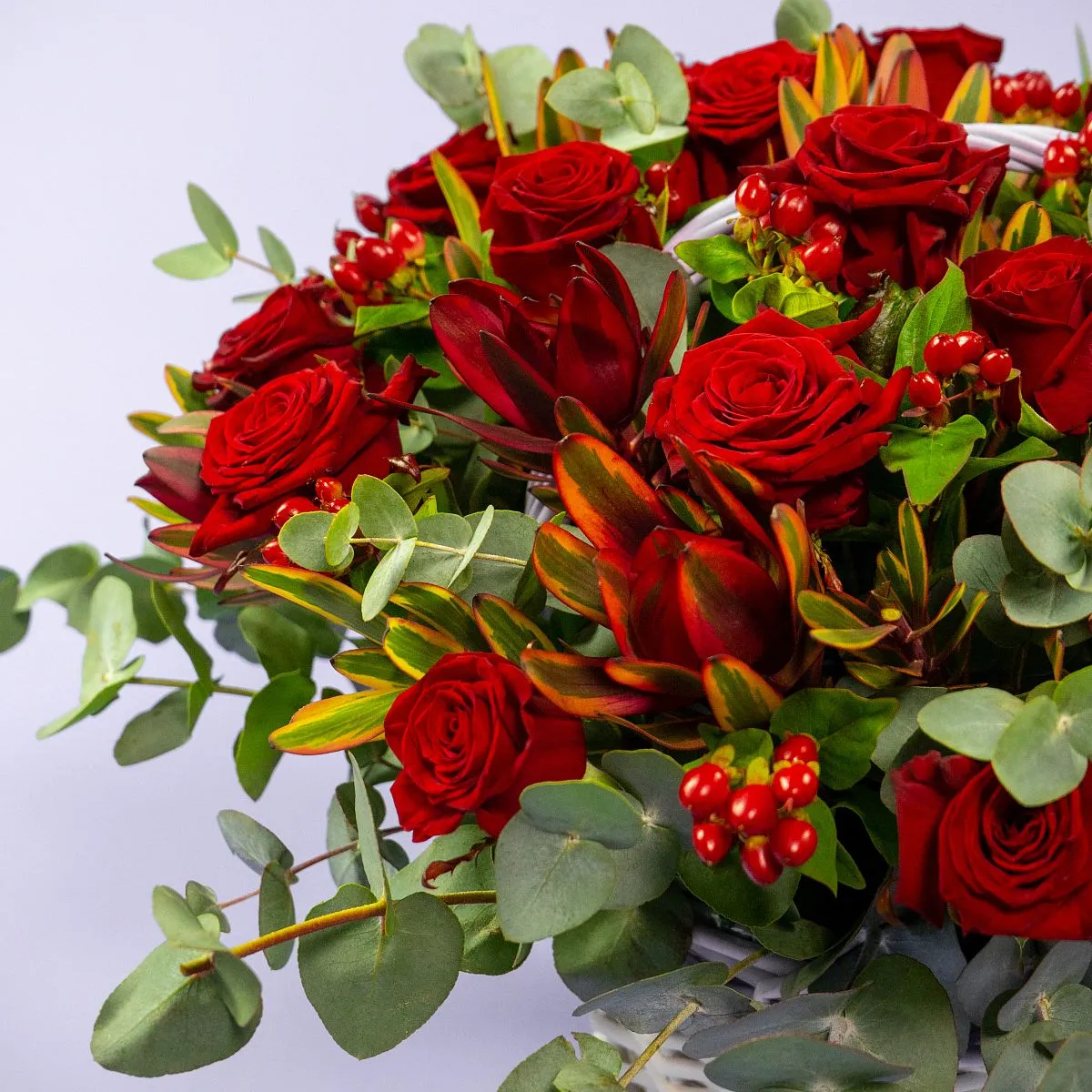 31 розы и эвкалипта в корзине